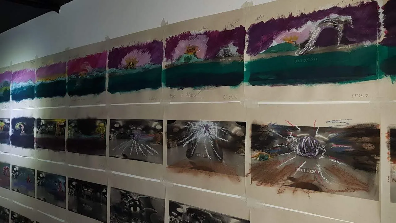 Parete del laboratorio di pittura con decine di fotogrammi stampati e dipinti ad acrilico, attaccati in sequenza con nastro adesivo e annotazioni