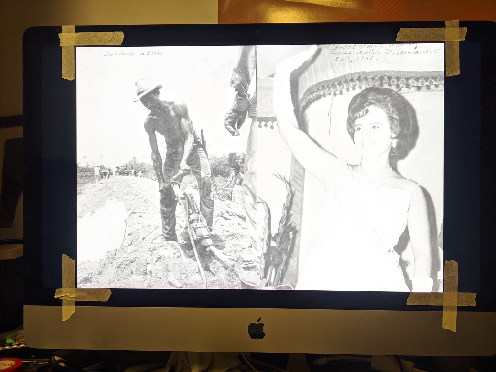 Fotografía de archivo en blanco y negro en la pantalla de un iMac, con cinta de enmascarar en las esquinas como marcas de encuadre.